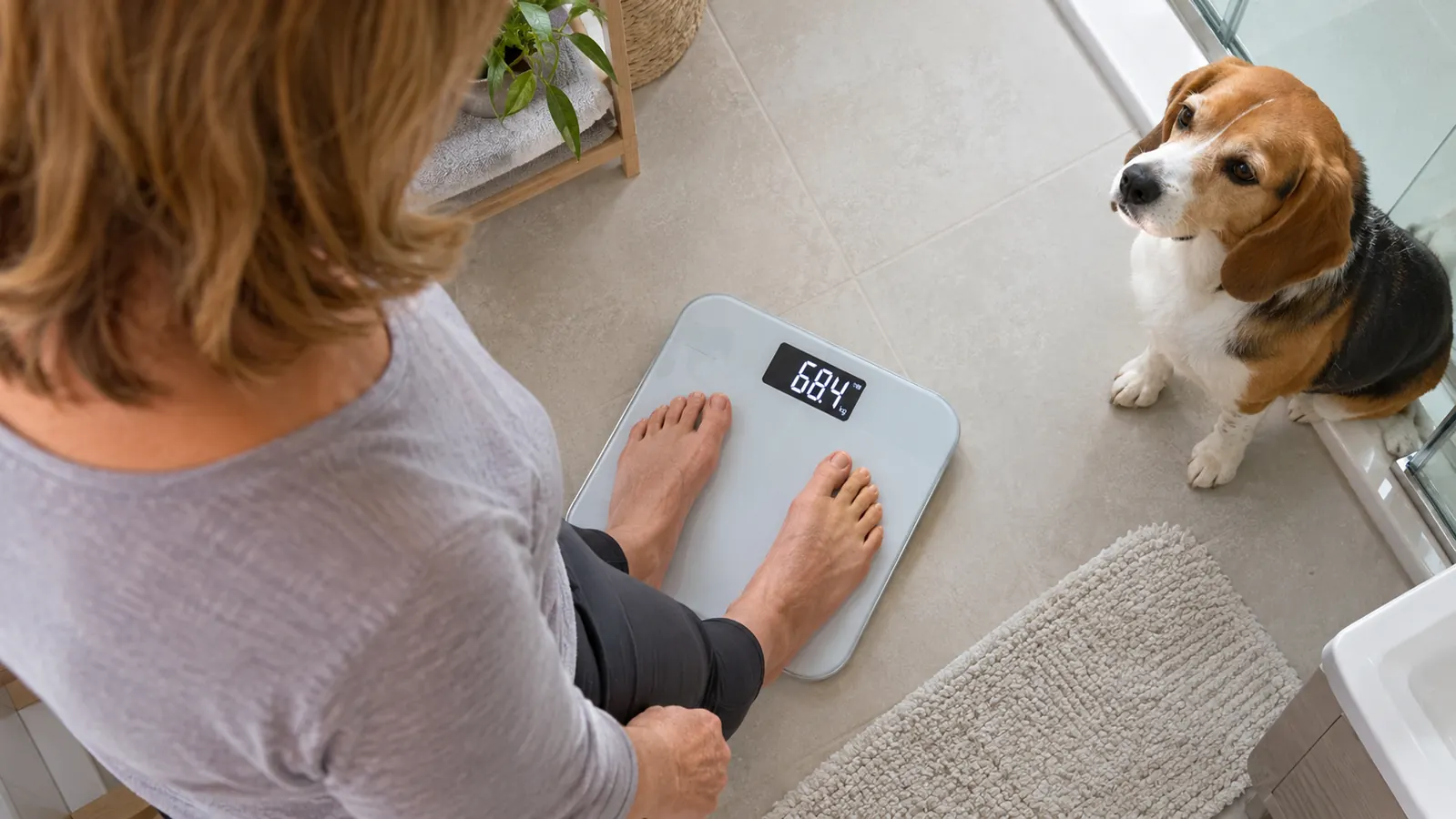 Bare feet on a digital scale while the display shows a weight reading.